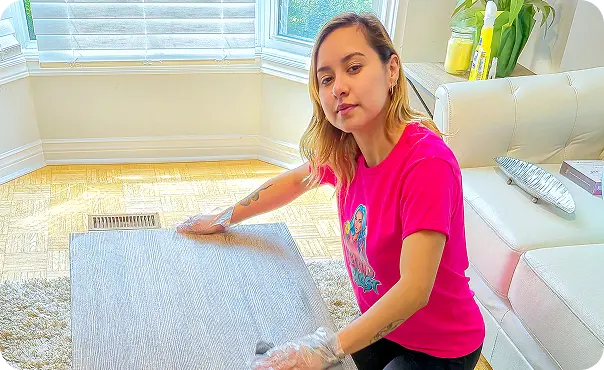 Cleaner cleaning a coffee table in the living room during a residential house cleaning.